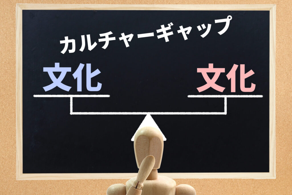 水色の文化とピンク色の文化が天秤にかけられており、顎に手をかけて悩む木製の人形